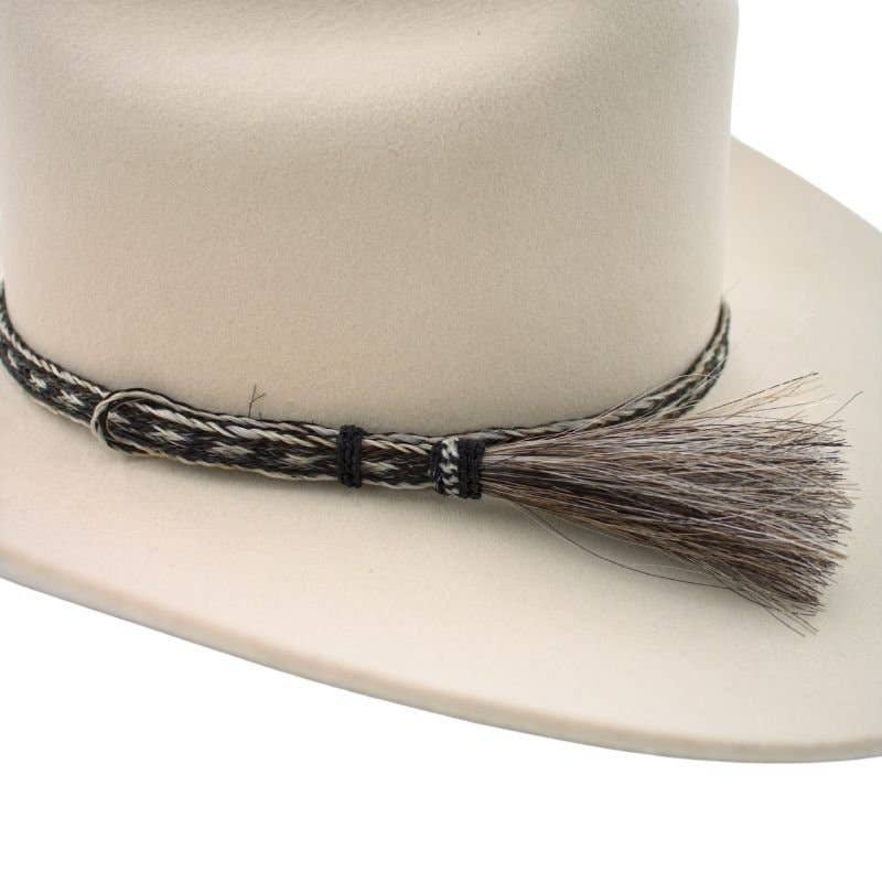 Light-colored cowboy hat with decorative band and tassel.