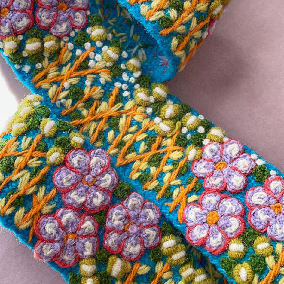 Blue embroidered fabric with floral pattern.