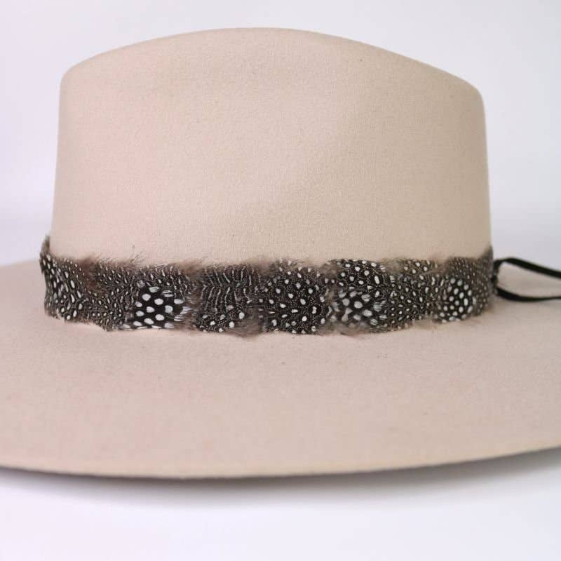 Beige fedora hat with feather band.
