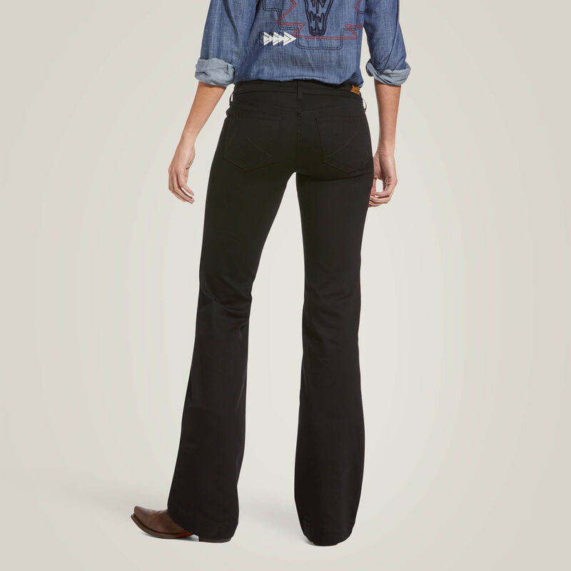 Woman wearing black flared jeans and denim shirt.