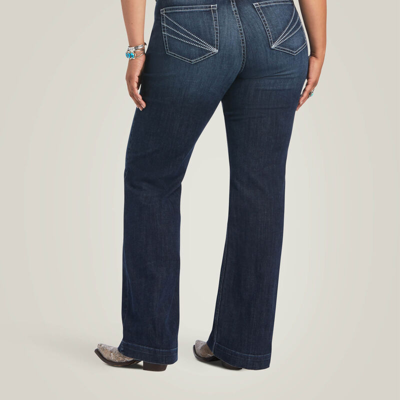 Woman wearing dark wash jeans.