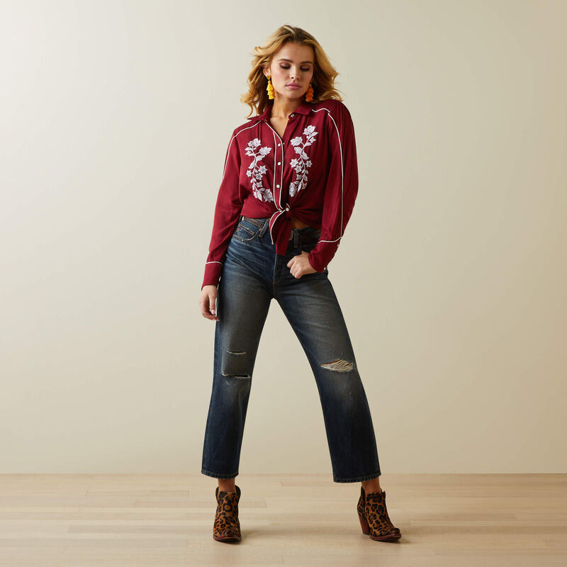 Woman in jeans and red floral shirt.