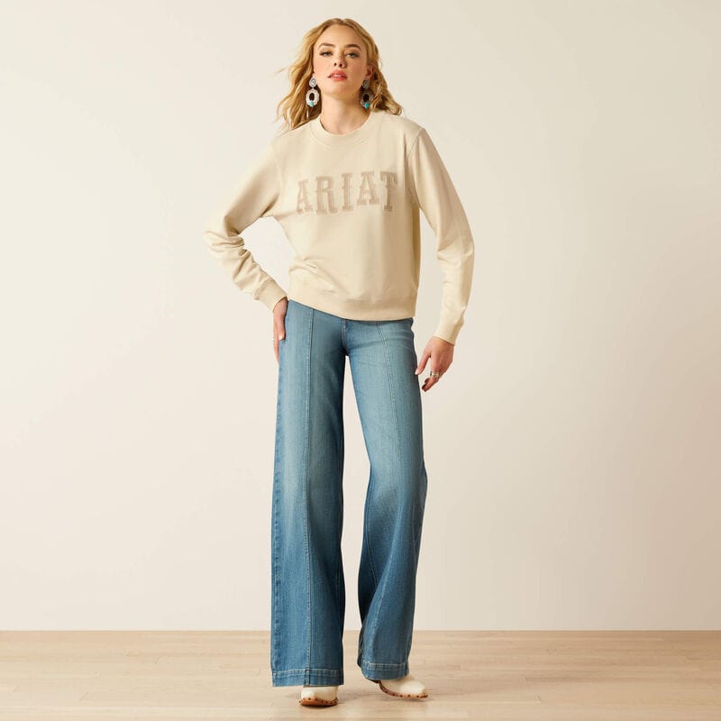 Woman in sweatshirt and wide-leg jeans.