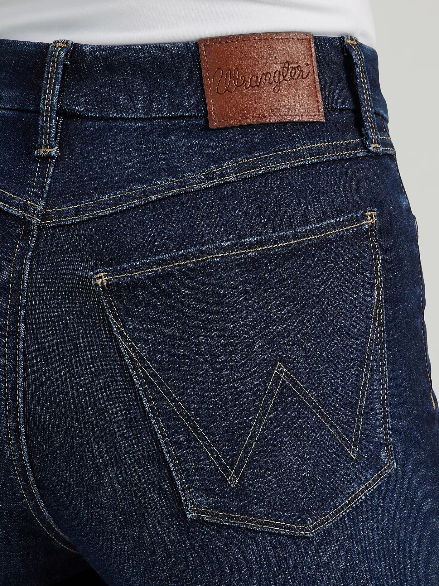Close-up of dark blue Wrangler jeans with back pocket.