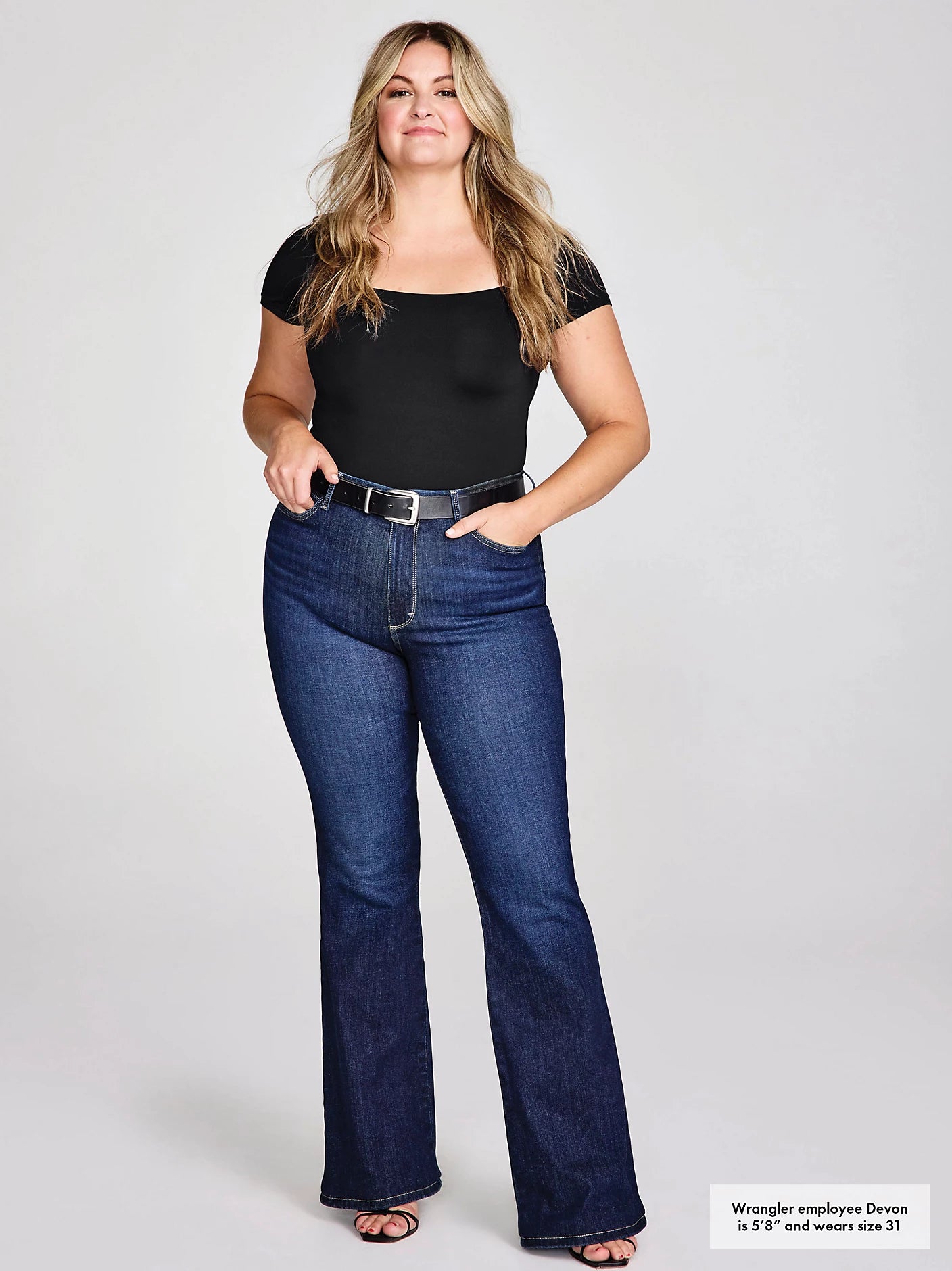 Woman in black top and blue jeans.