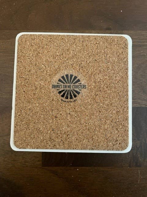 Square cork coaster with white trim and logo.
