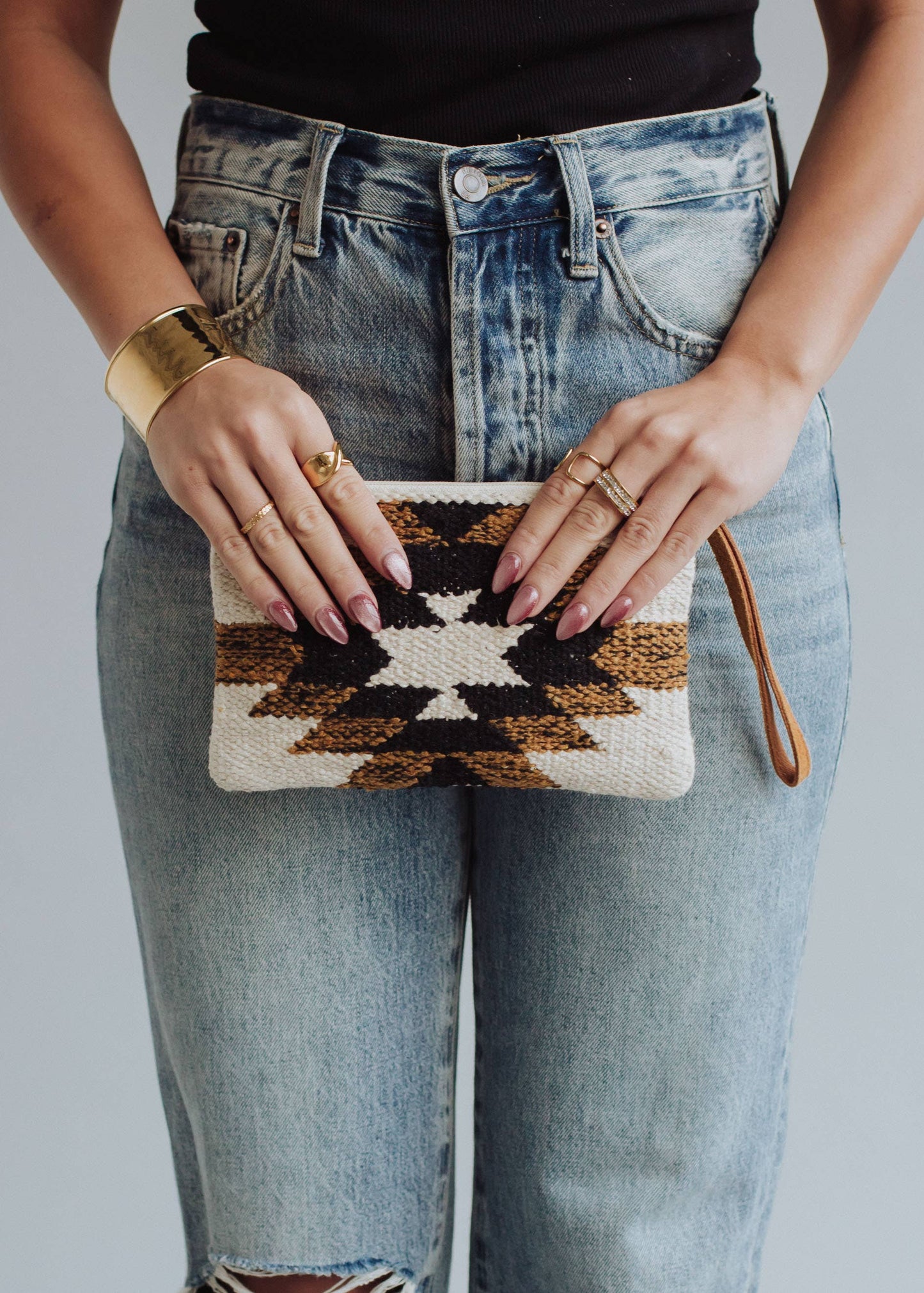 Woman holding patterned clutch.