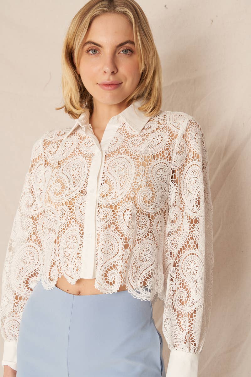 Woman in white lace shirt and blue pants.