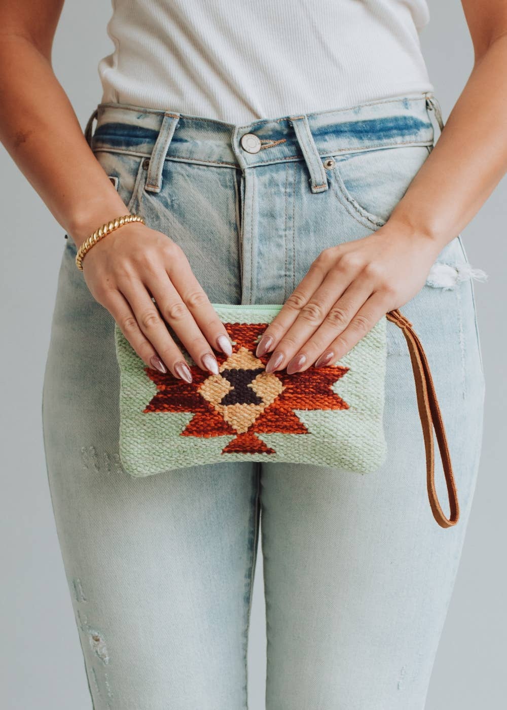 Woman holding a patterned clutch purse.