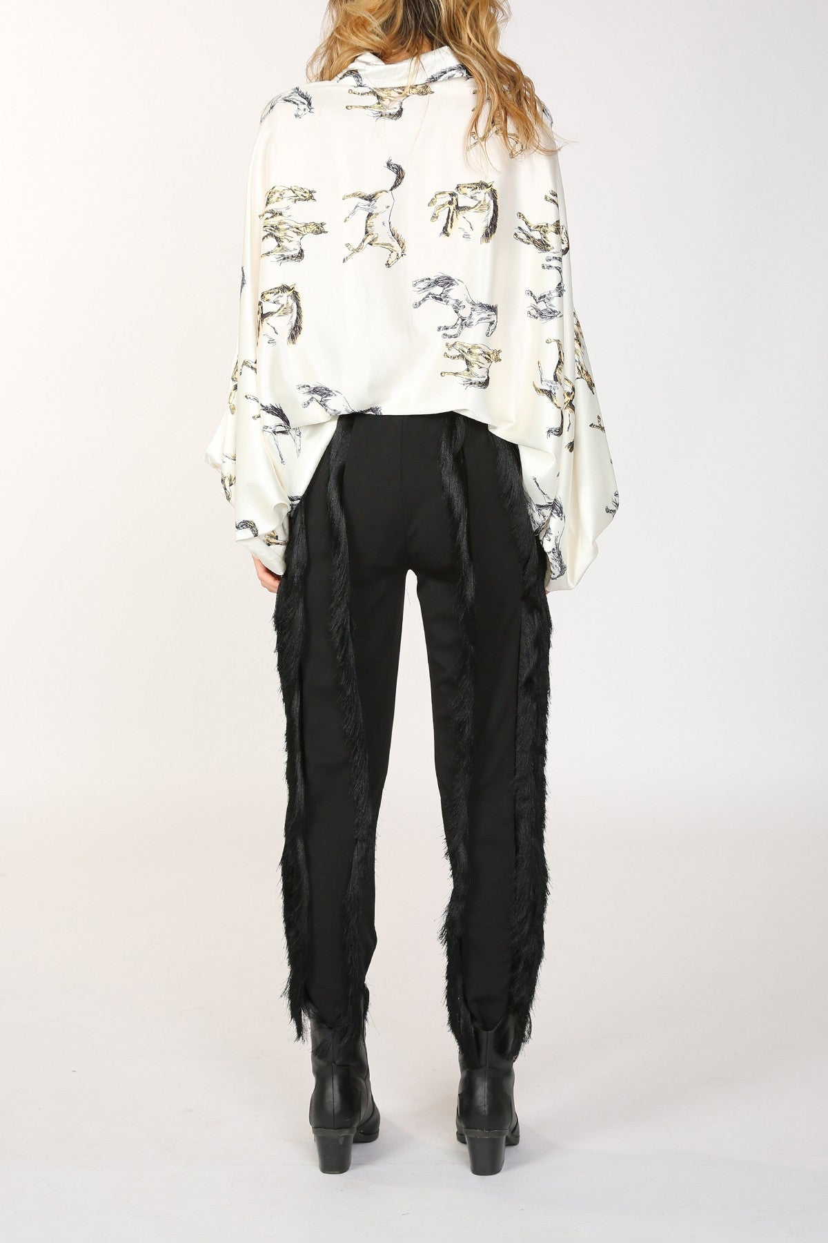 Woman in patterned shirt and black pants.