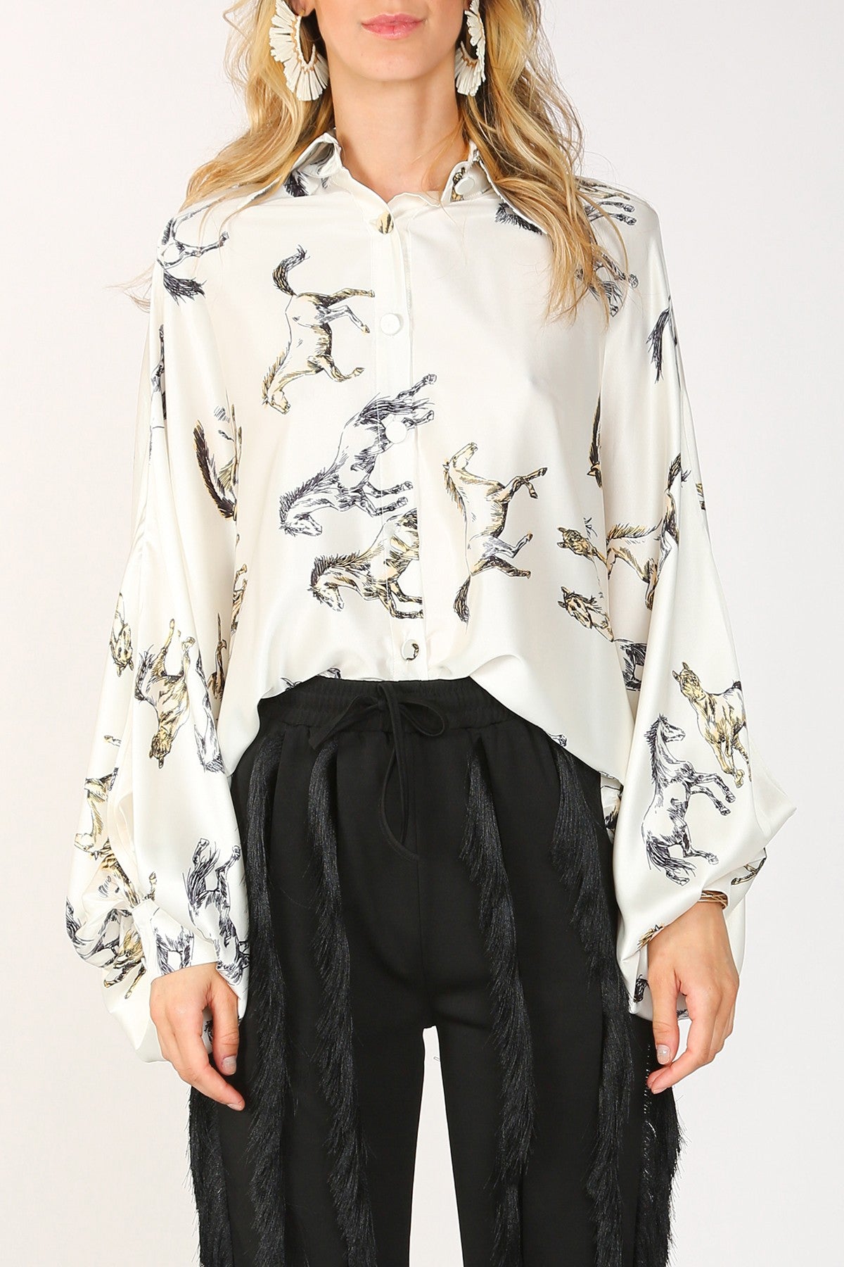 Woman wearing a white shirt with cat print and black pants.