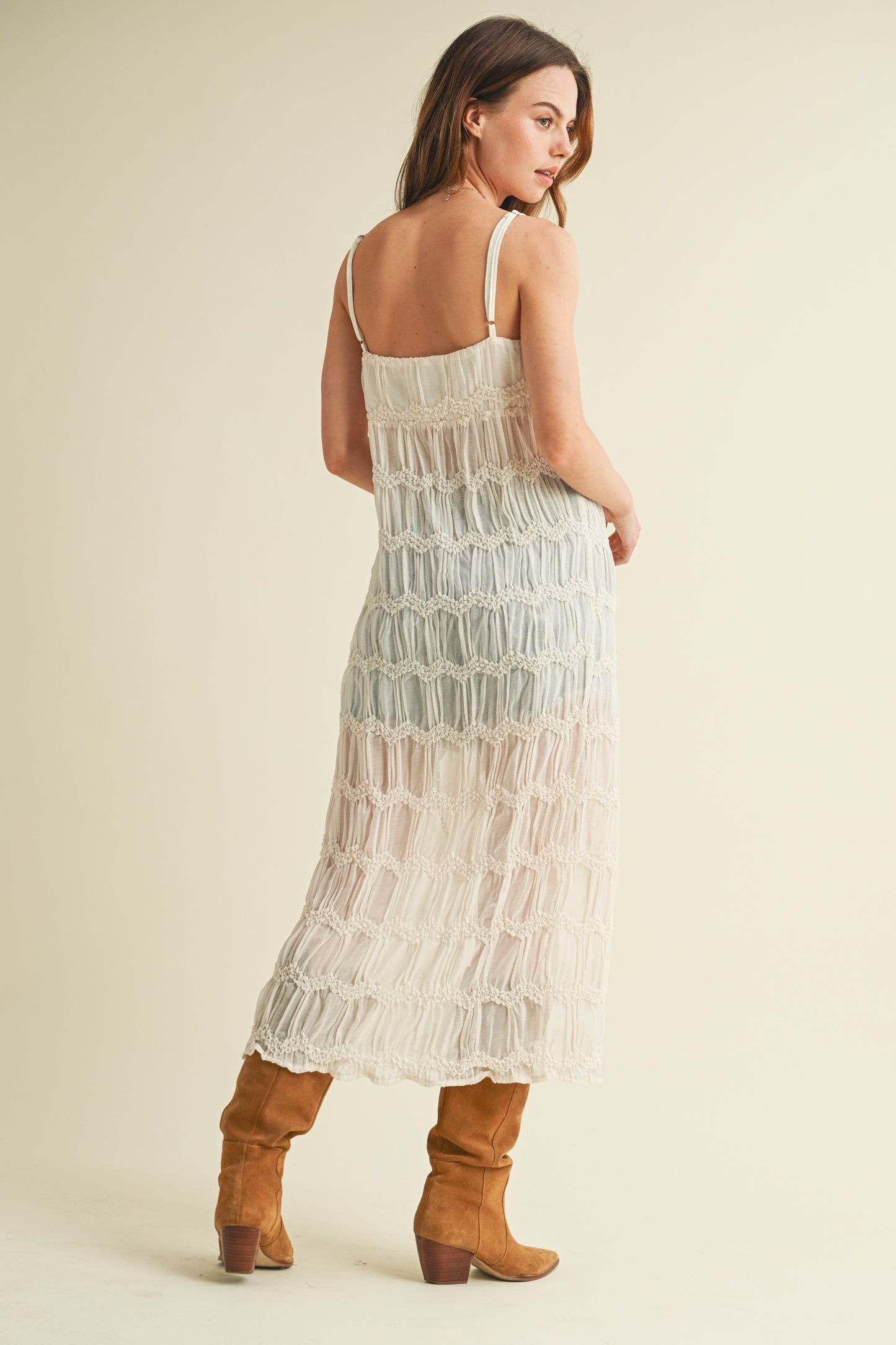Woman in white dress and brown boots.