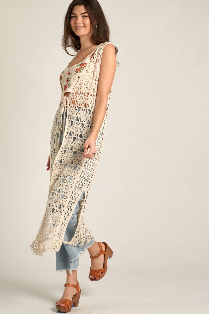 Woman in crochet vest and jeans.