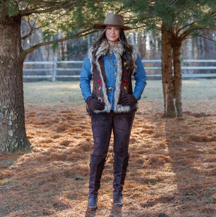 Woman in brown vest and pants, hat