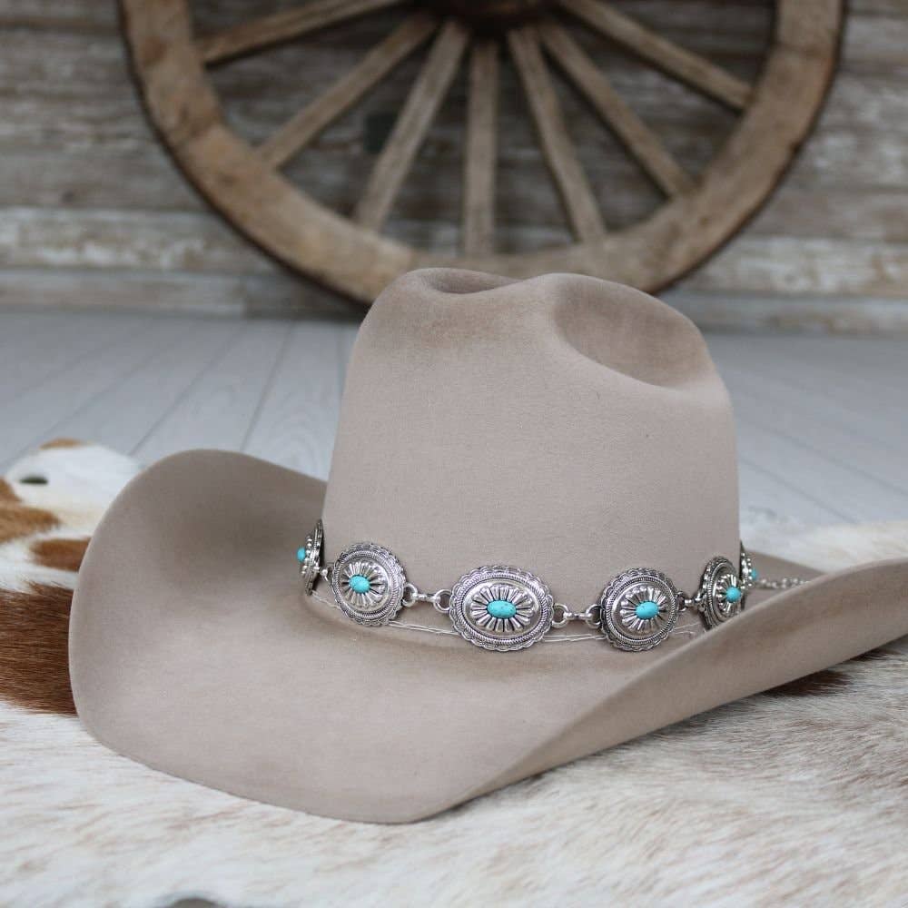 Tan cowboy hat with turquoise and silver embellishment.
