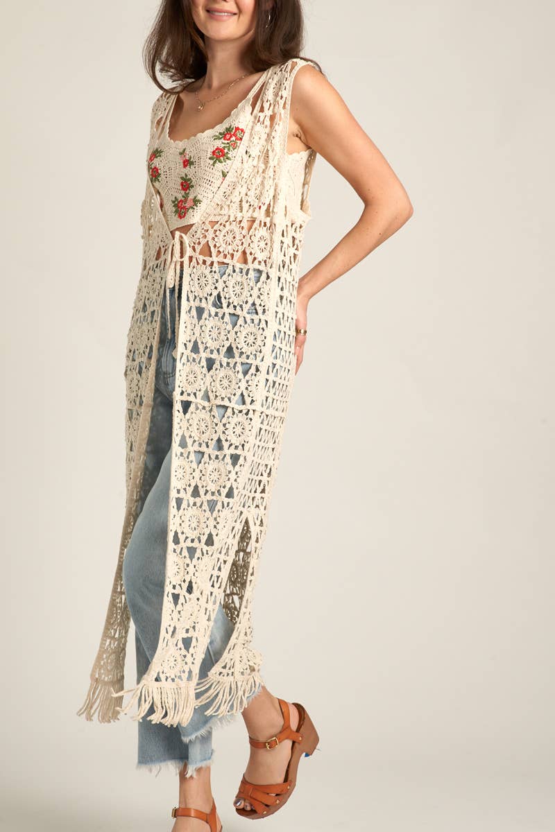 Woman in crochet vest and jeans.