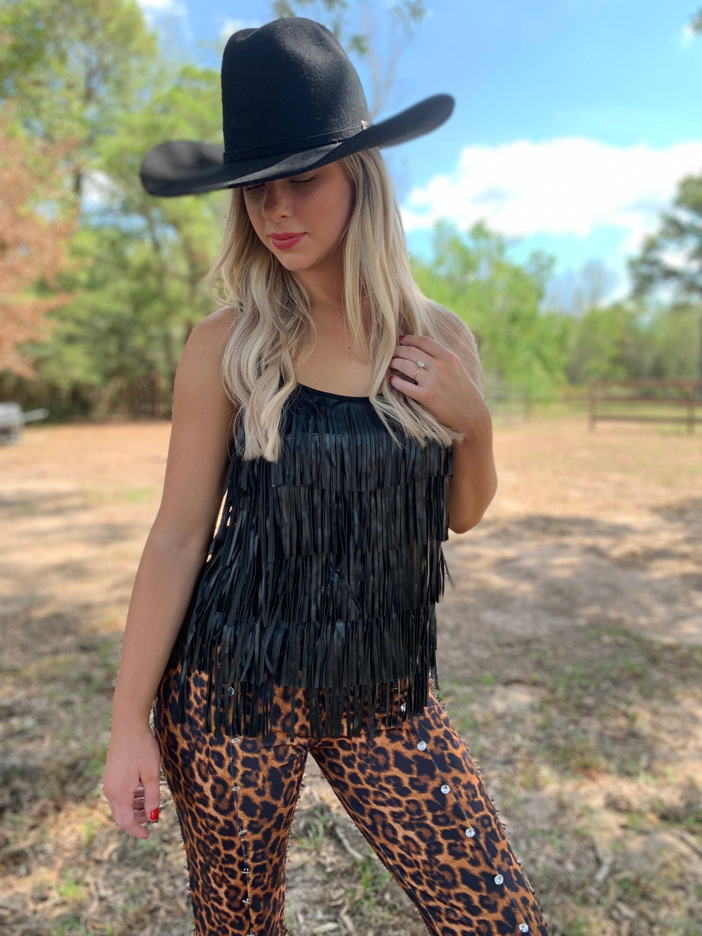 Woman in fringe top and leopard pants, cowboy hat