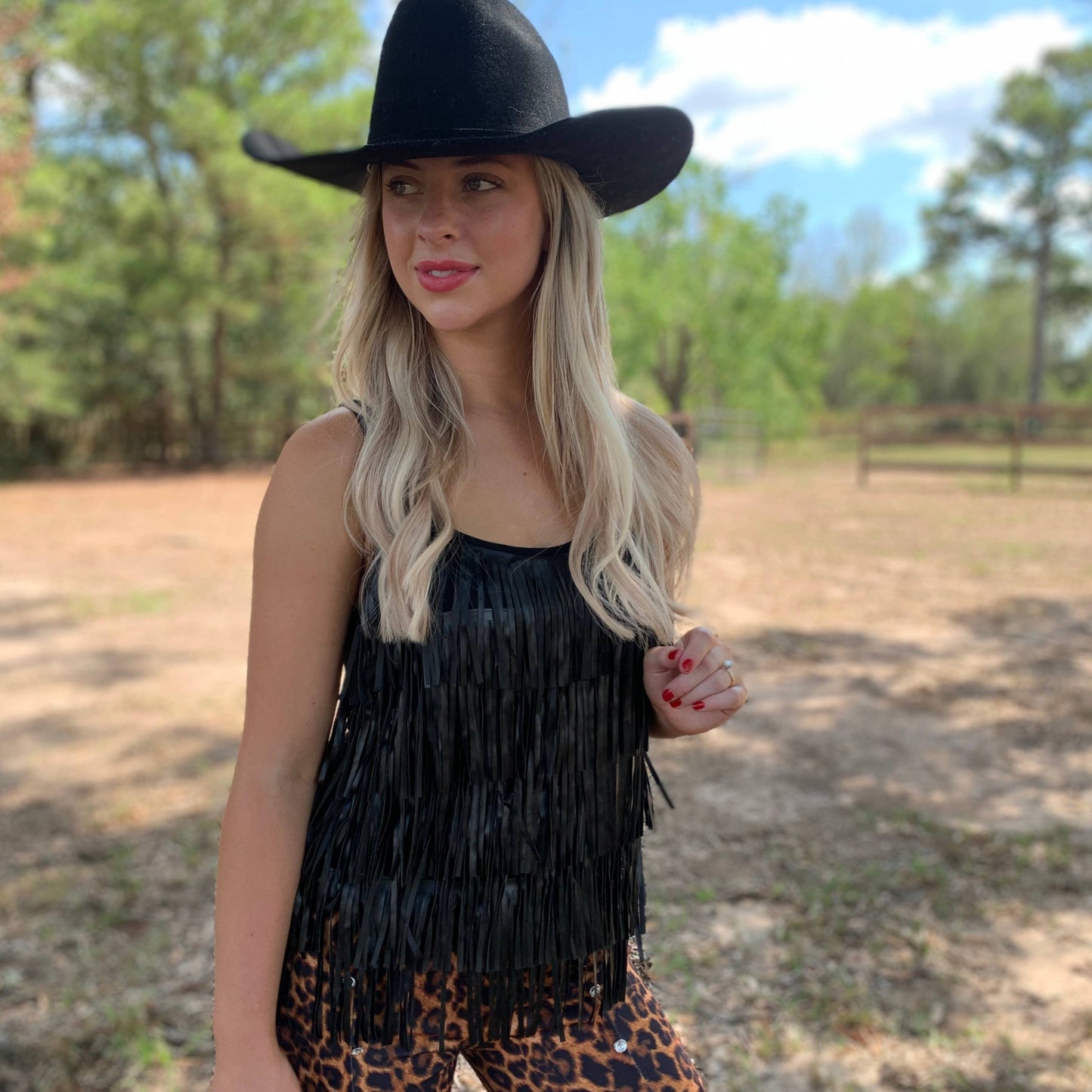 Woman in black fringe top and cowboy hat