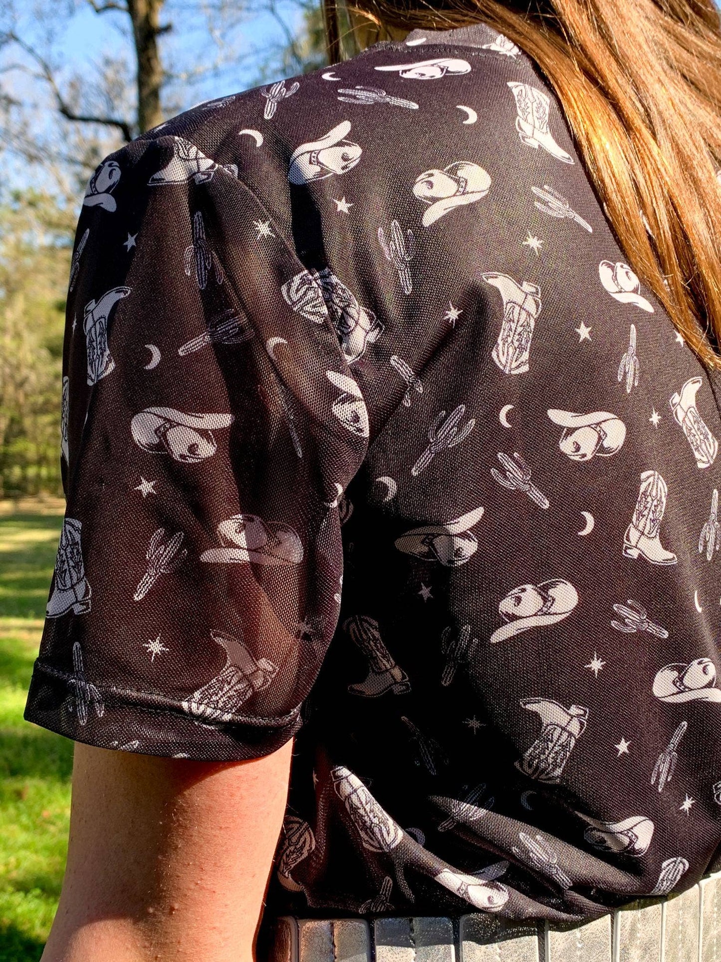 Woman wearing black shirt with cowboy print.