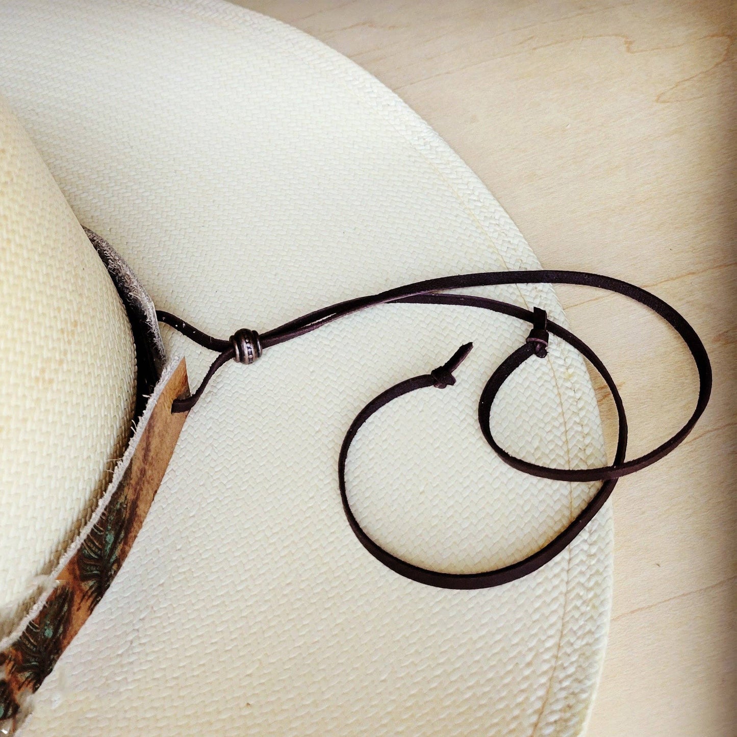 White cowboy hat with leather chin strap.