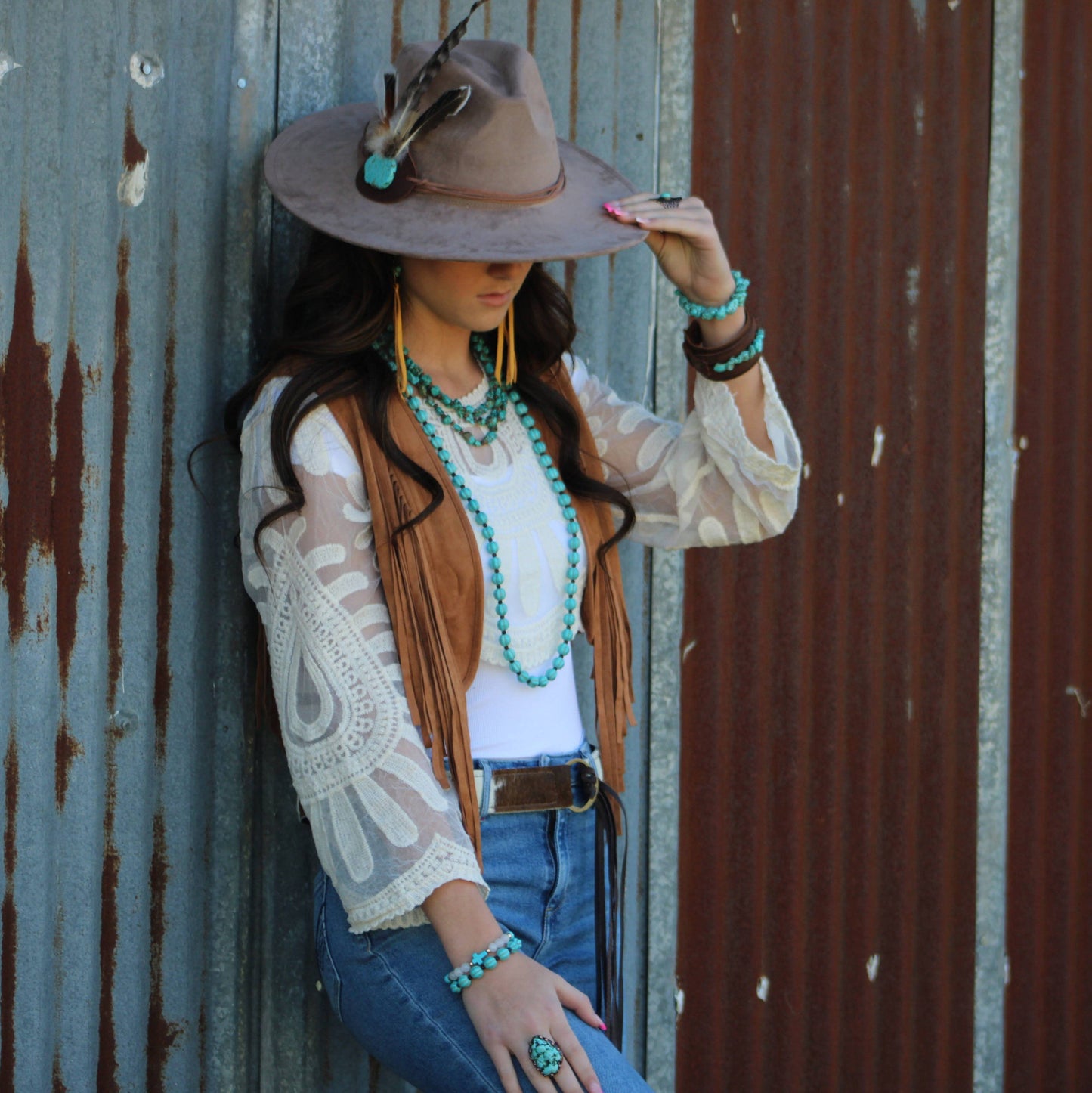 Woman in cowboy hat and jewelry.