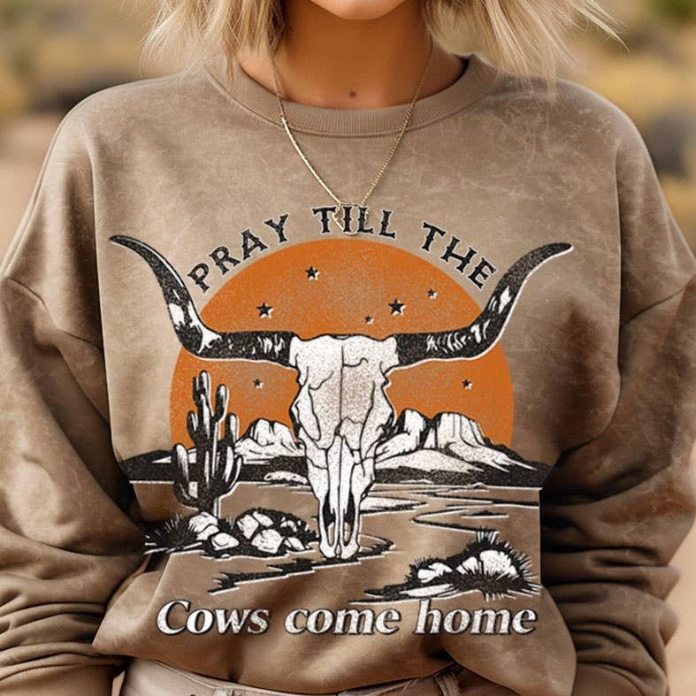 Woman wearing a sweatshirt with a bull skull graphic.