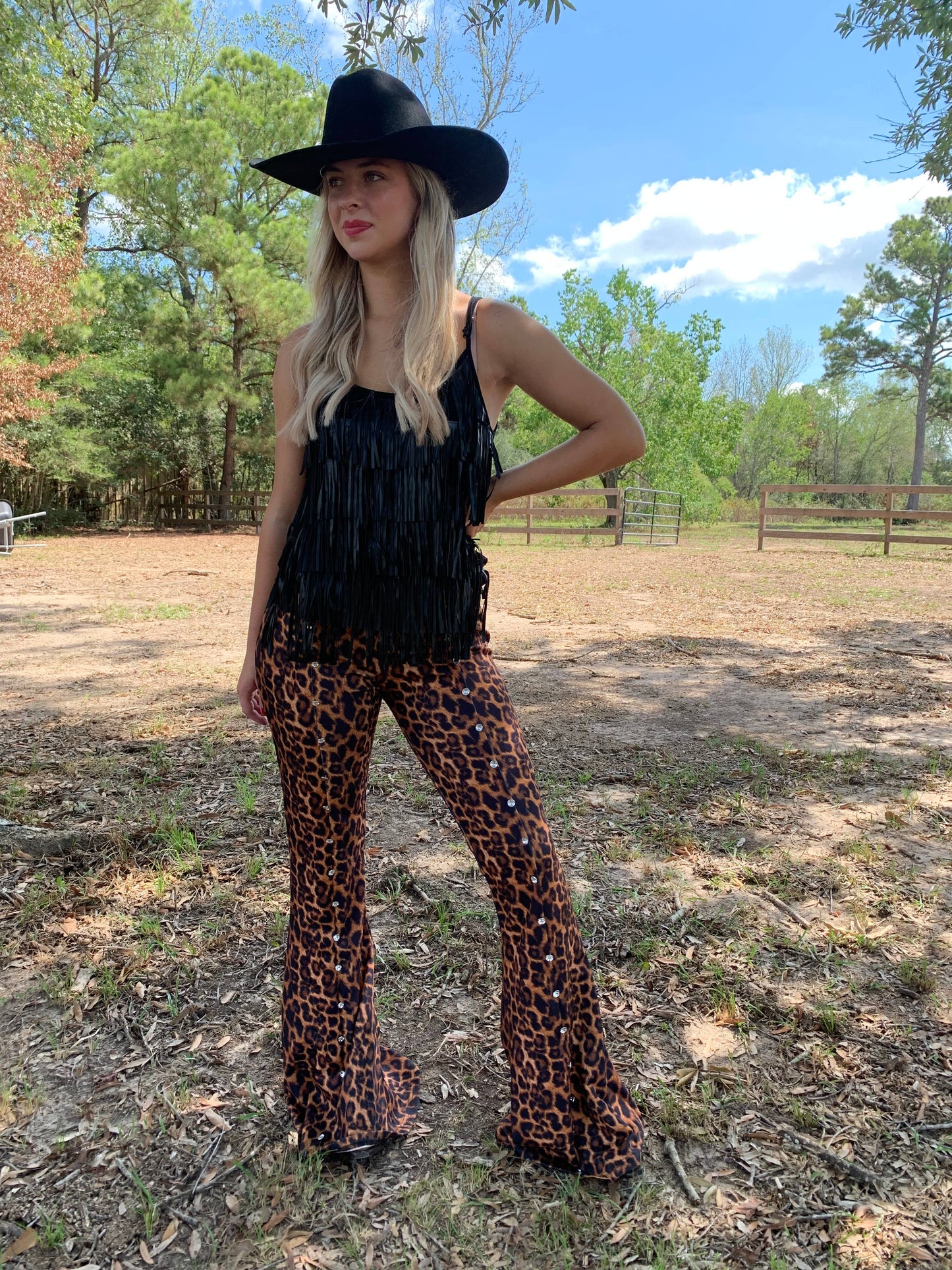 Woman in leopard print pants and fringe top.