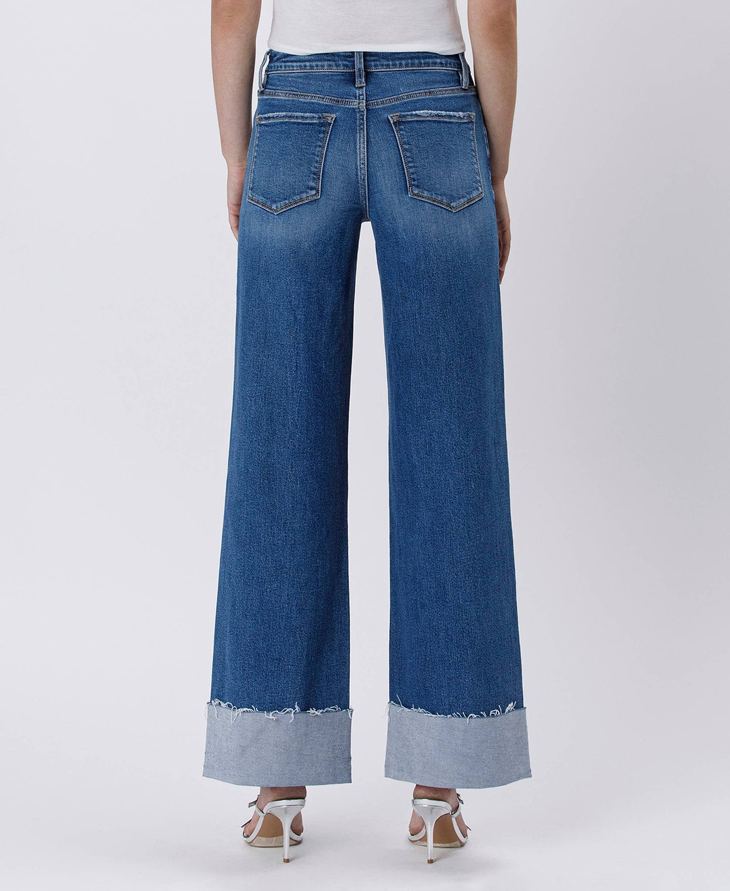 Woman wearing blue wide-leg jeans with cuffed hems.