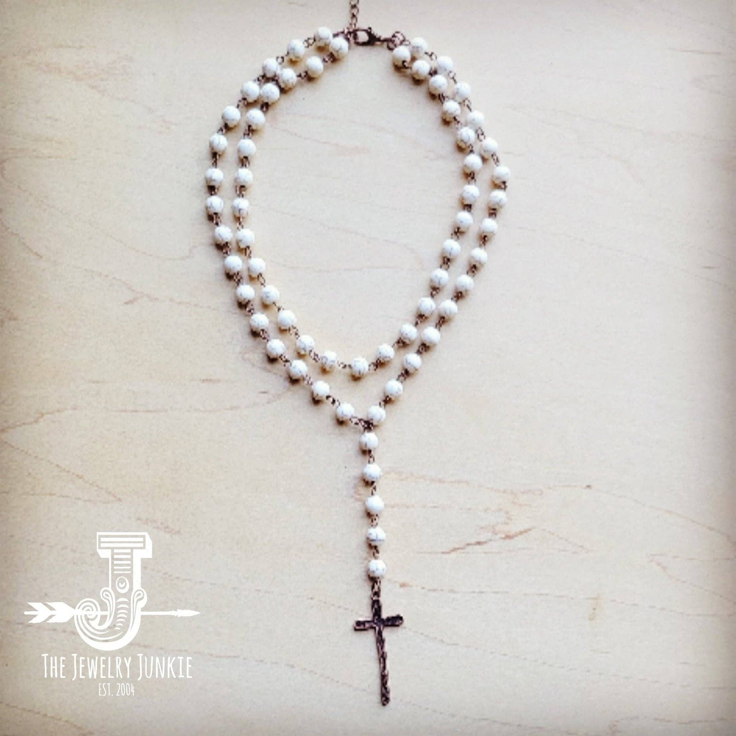 White beaded necklace with a cross pendant.