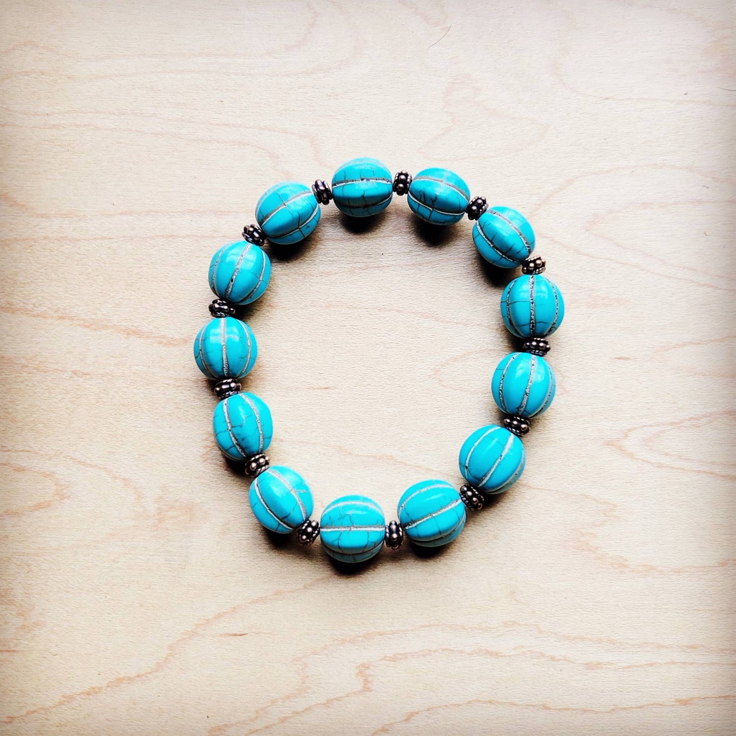 Turquoise beaded bracelet on a wood surface.