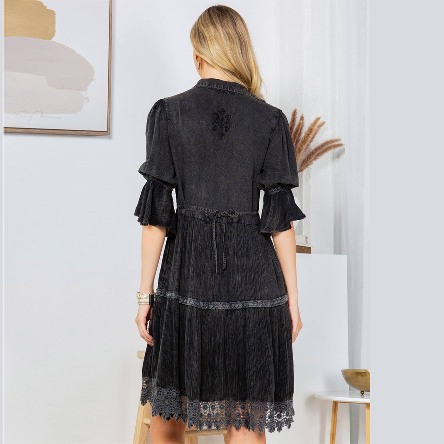 Woman in black dress from behind.