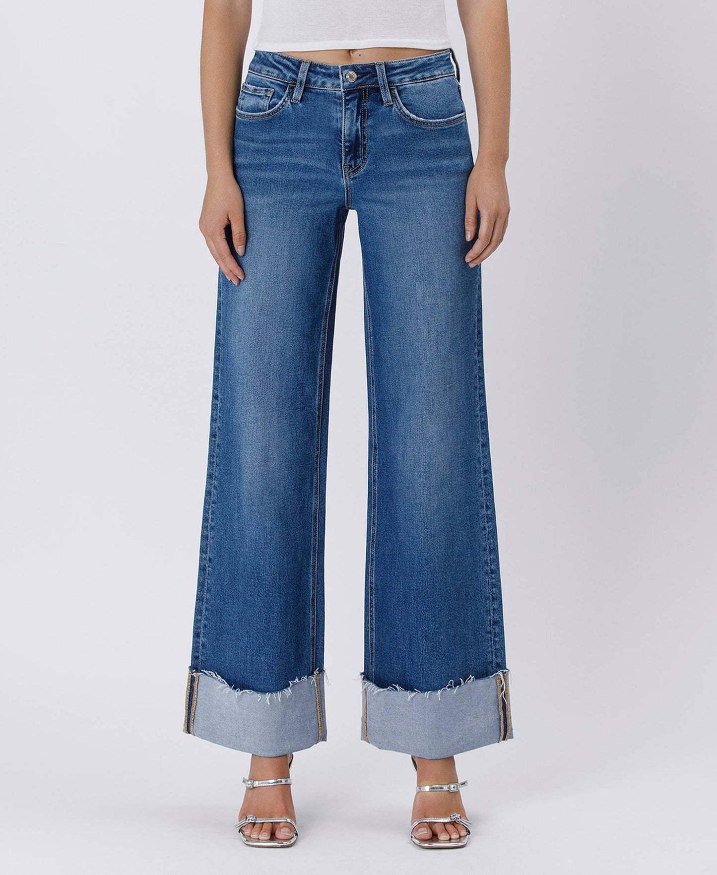 Woman wearing blue wide-leg jeans with cuffed hems.