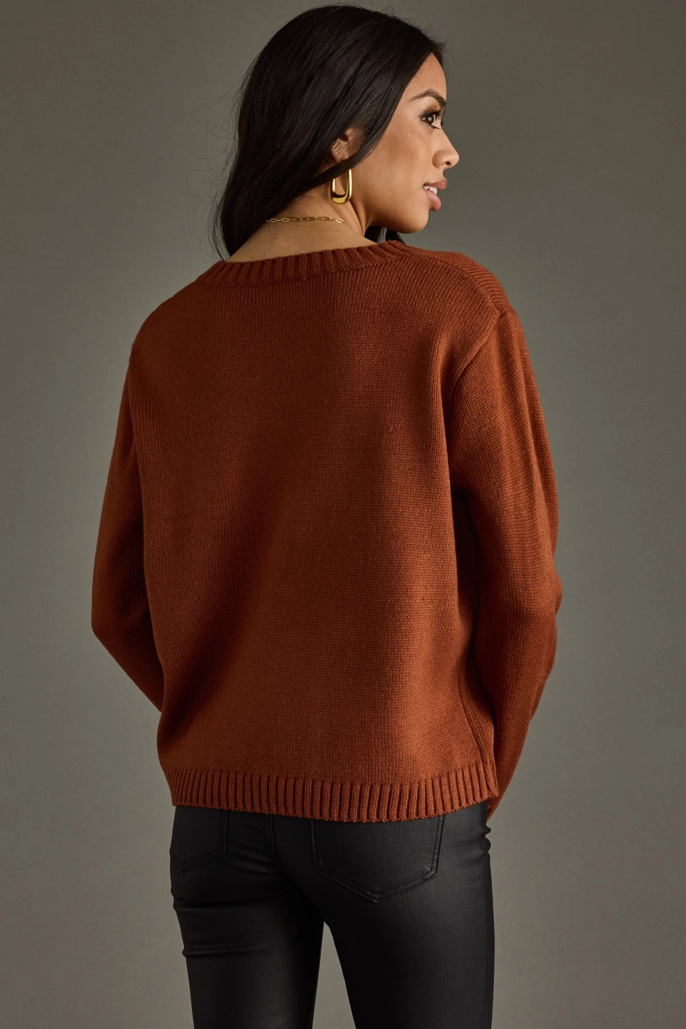 Woman in brown sweater and black pants.