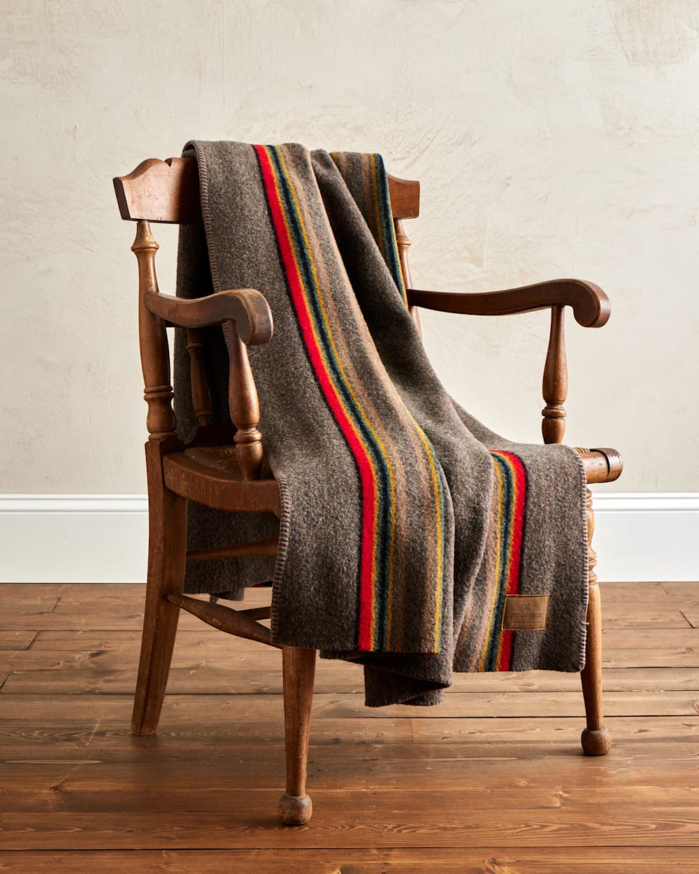 Brown blanket with stripes draped over wooden chair