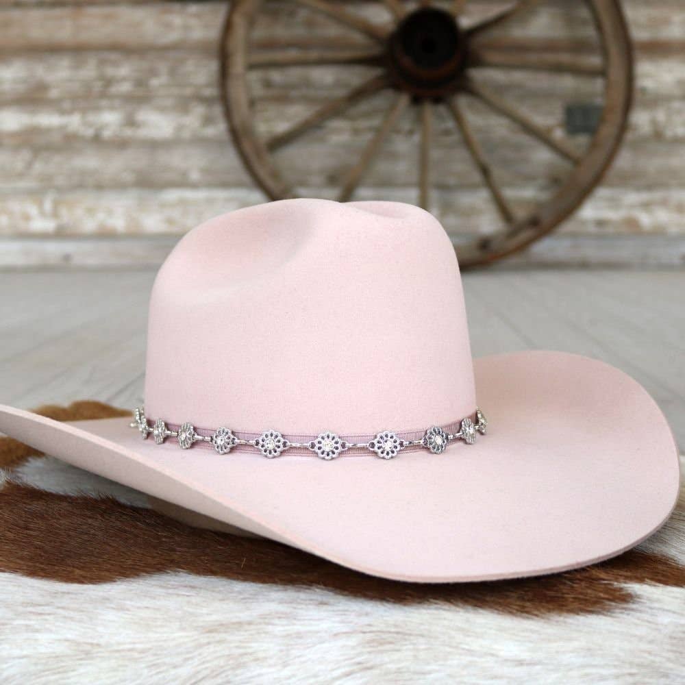 Pink cowboy hat with decorative band.