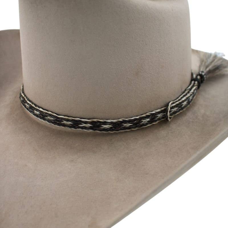 Cowboy hat with woven band and tassel.