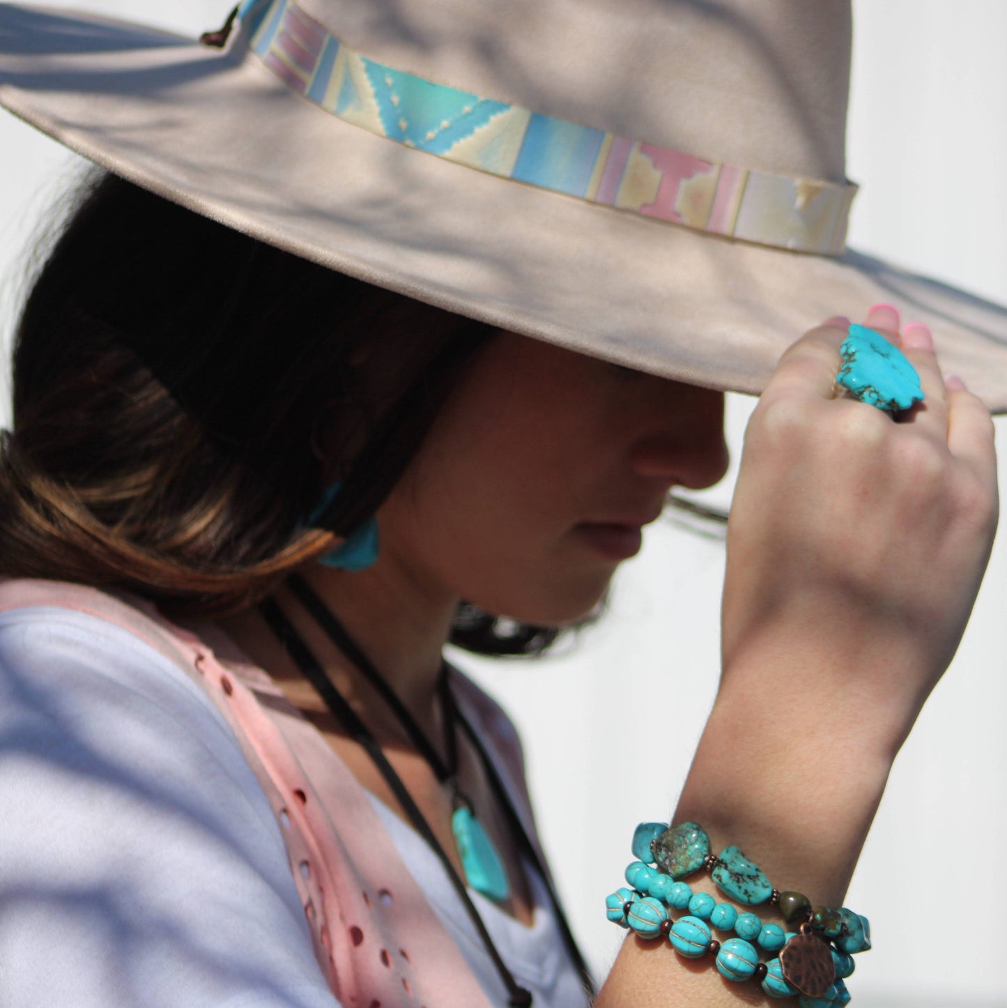 Woman in hat with turquoise jewelry.
