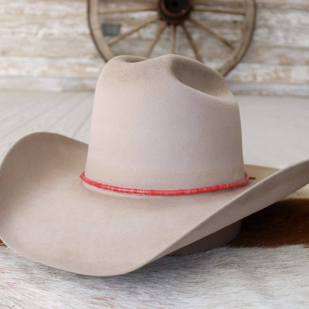 Tan cowboy hat with red band.