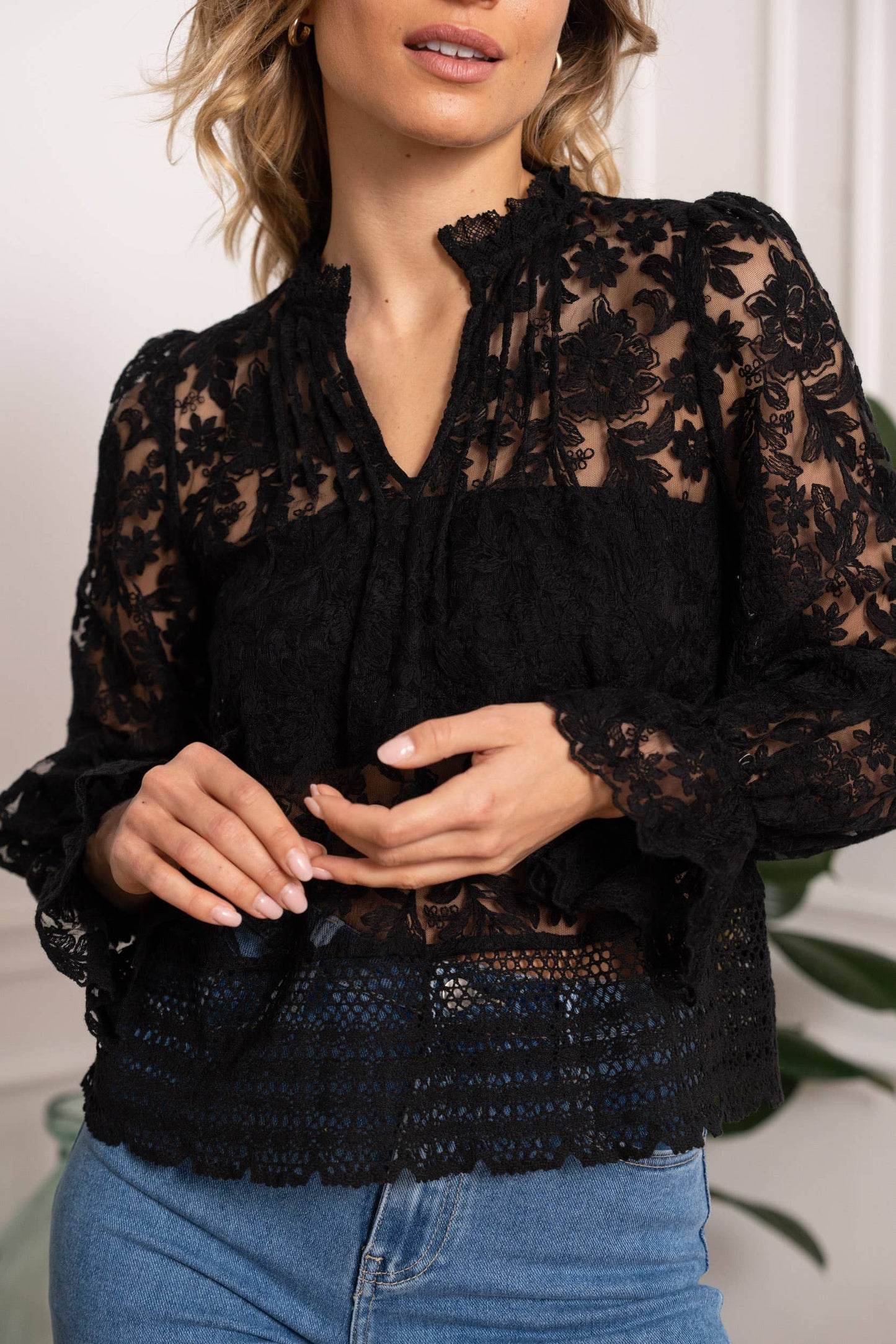 Woman wearing a black lace blouse.