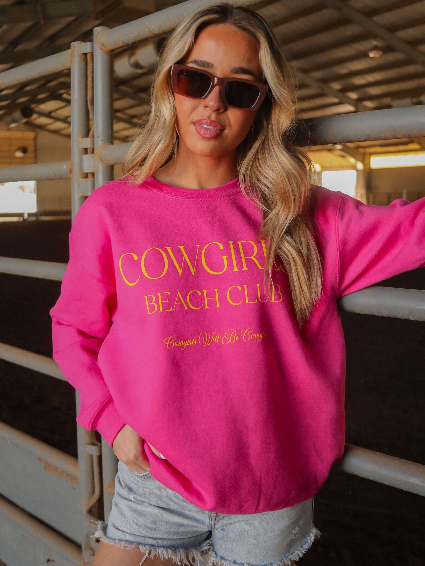 Woman wearing pink sweatshirt and sunglasses