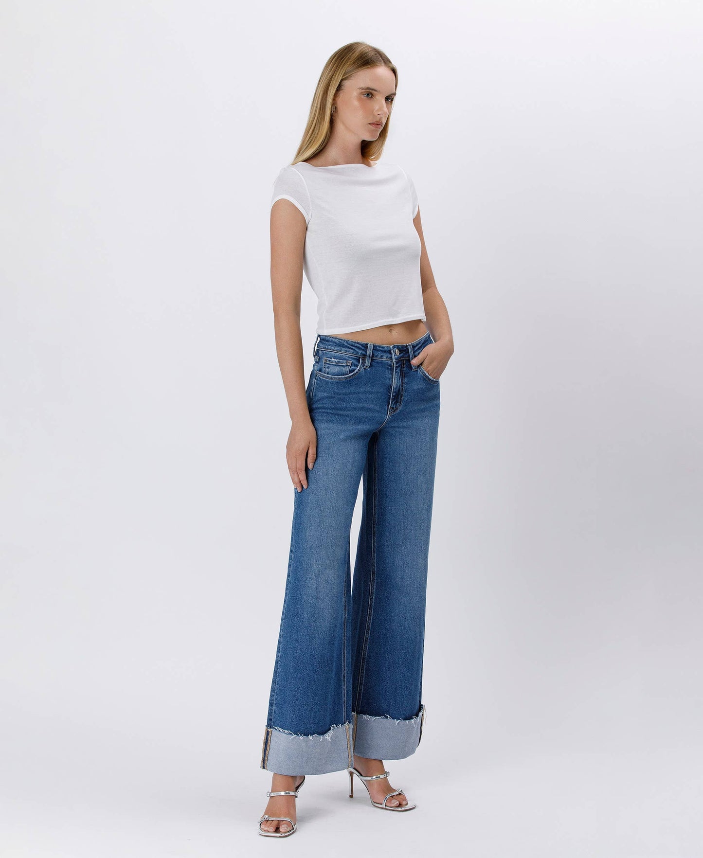 Woman in white top and wide-leg jeans.
