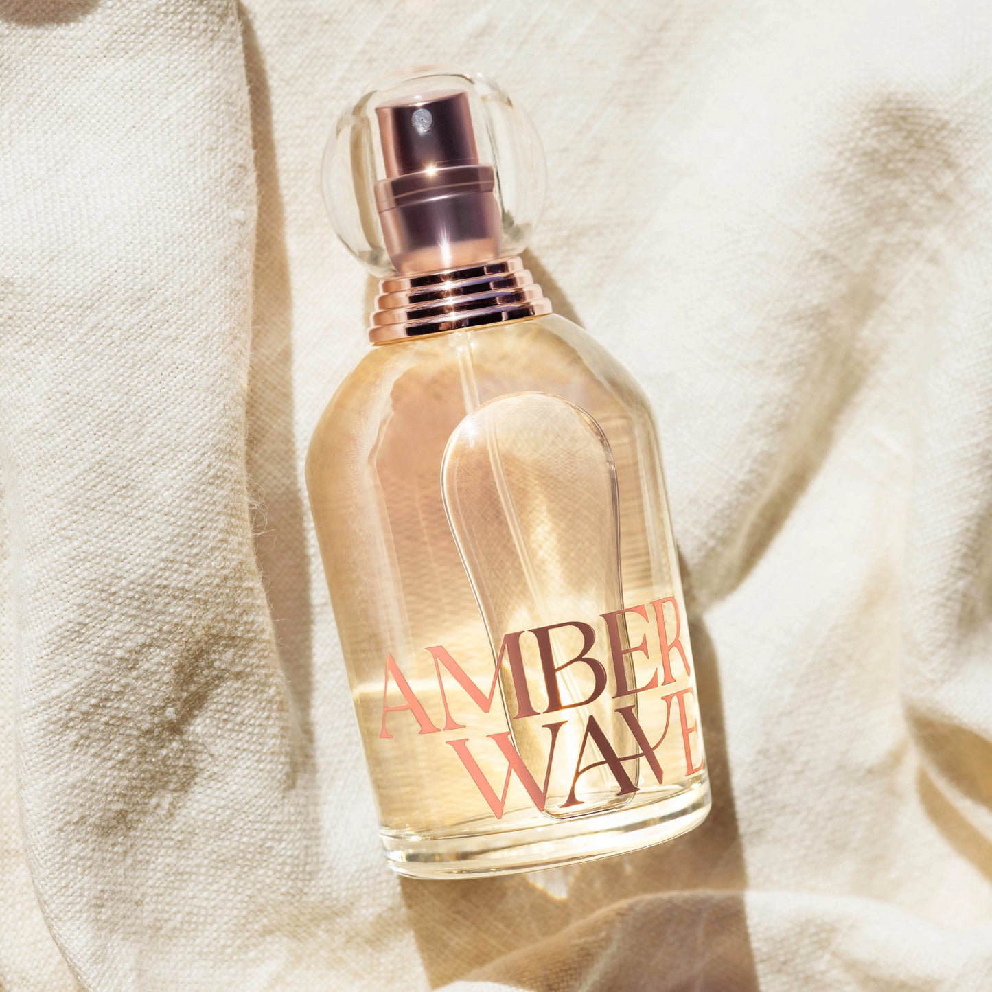 Amber Wave perfume bottle on white linen