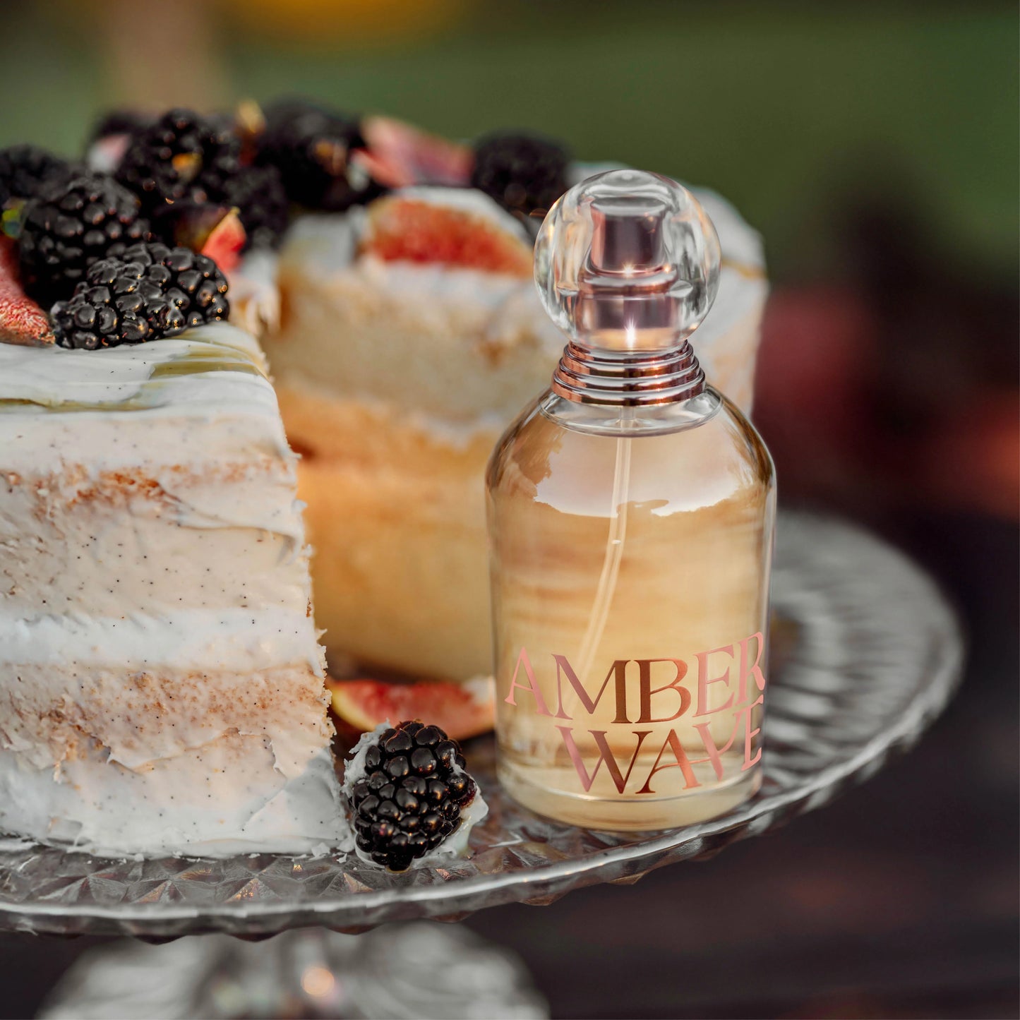 Amber Waves perfume bottle next to cake with blackberries