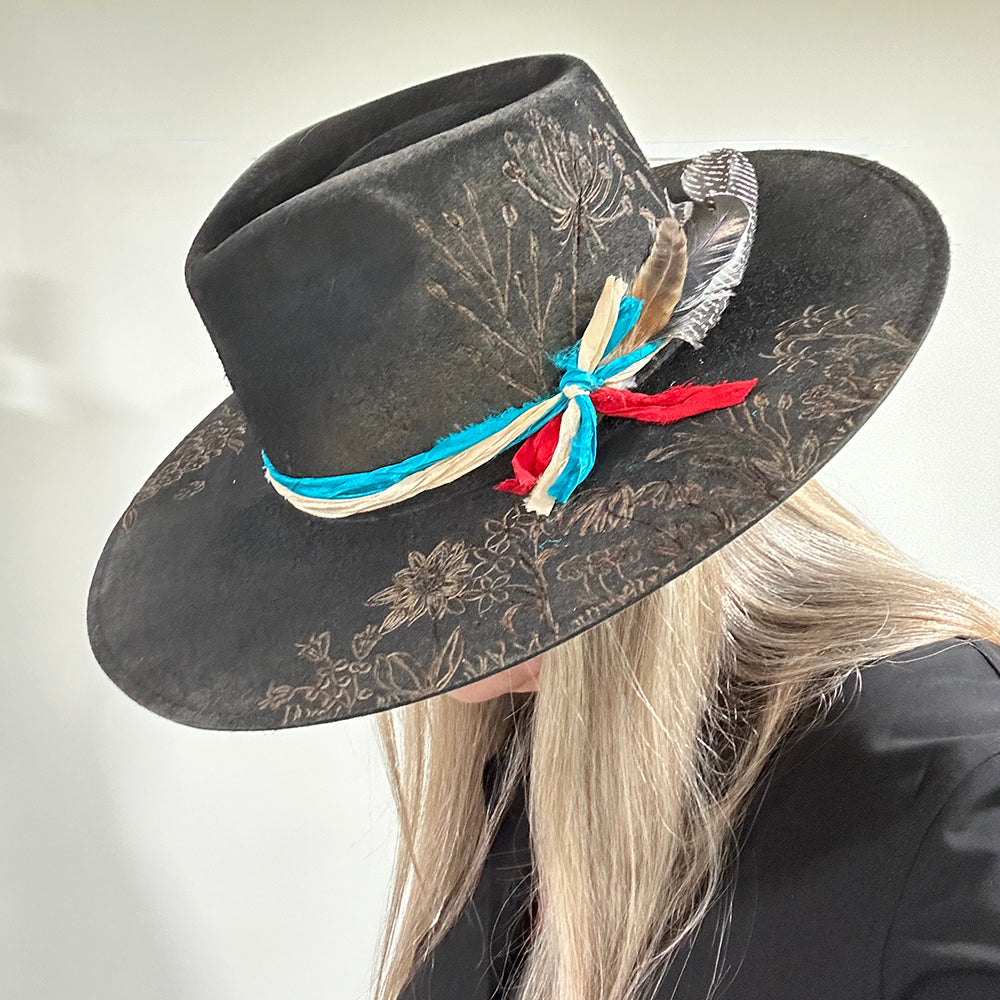 Black hat with floral design and feathers