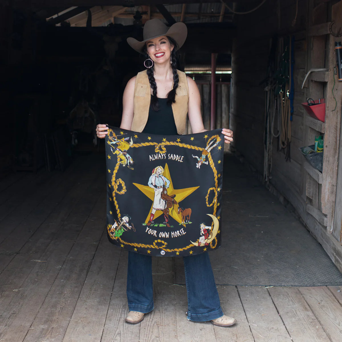 Cowgirl holding Always Saddle Your Own Horse banner