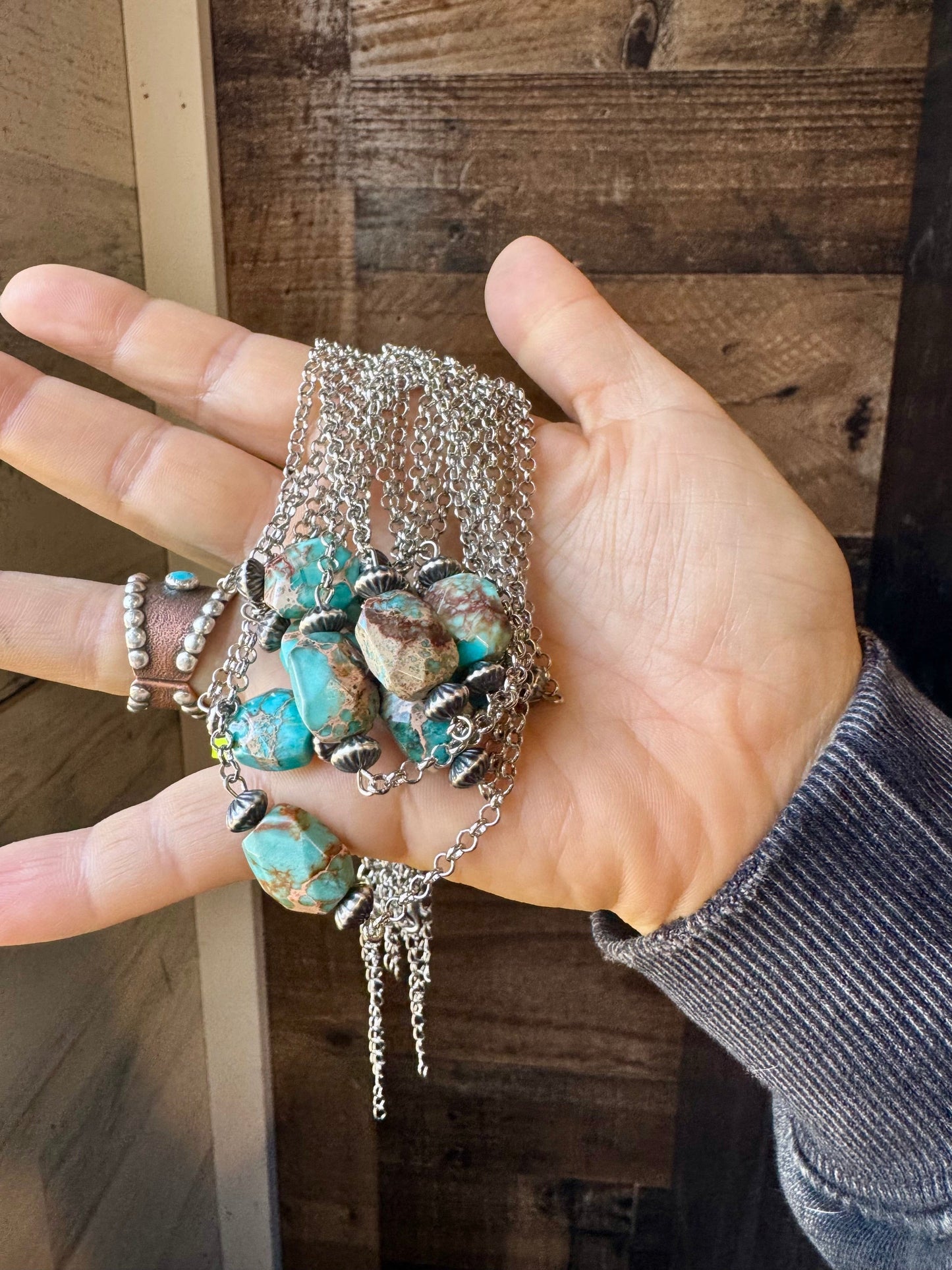 Turquoise beaded necklace held in hand - EC472120