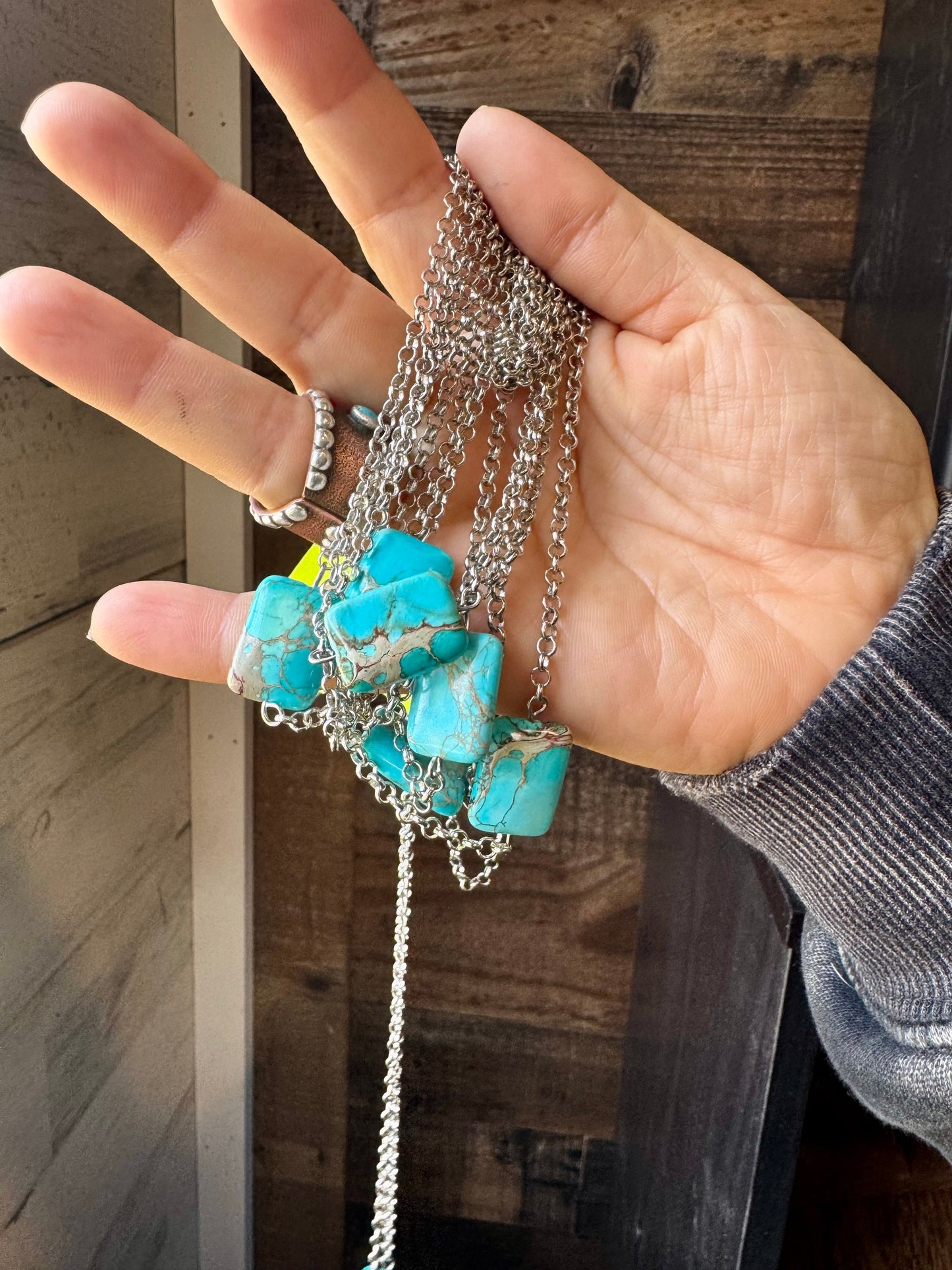 Turquoise stone necklaces held in hand