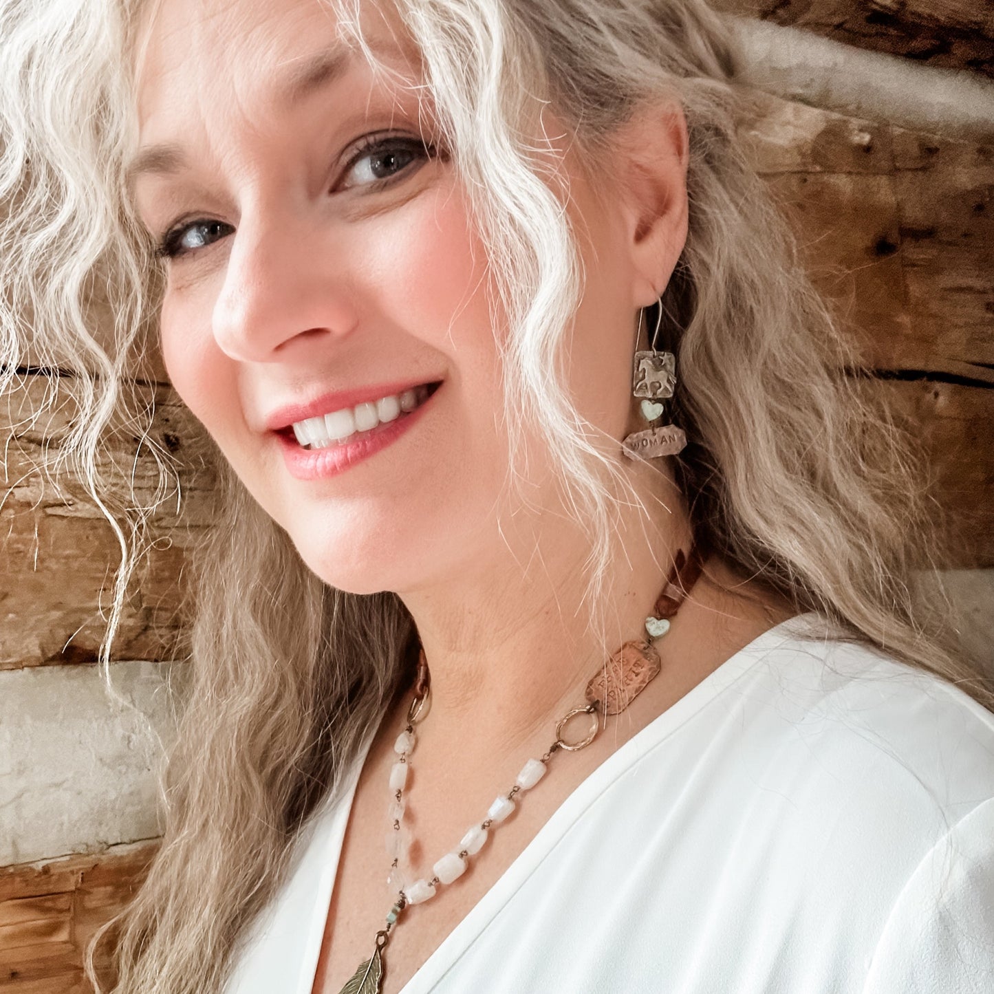 Smiling woman with long wavy hair and jewelry, Facetune edit