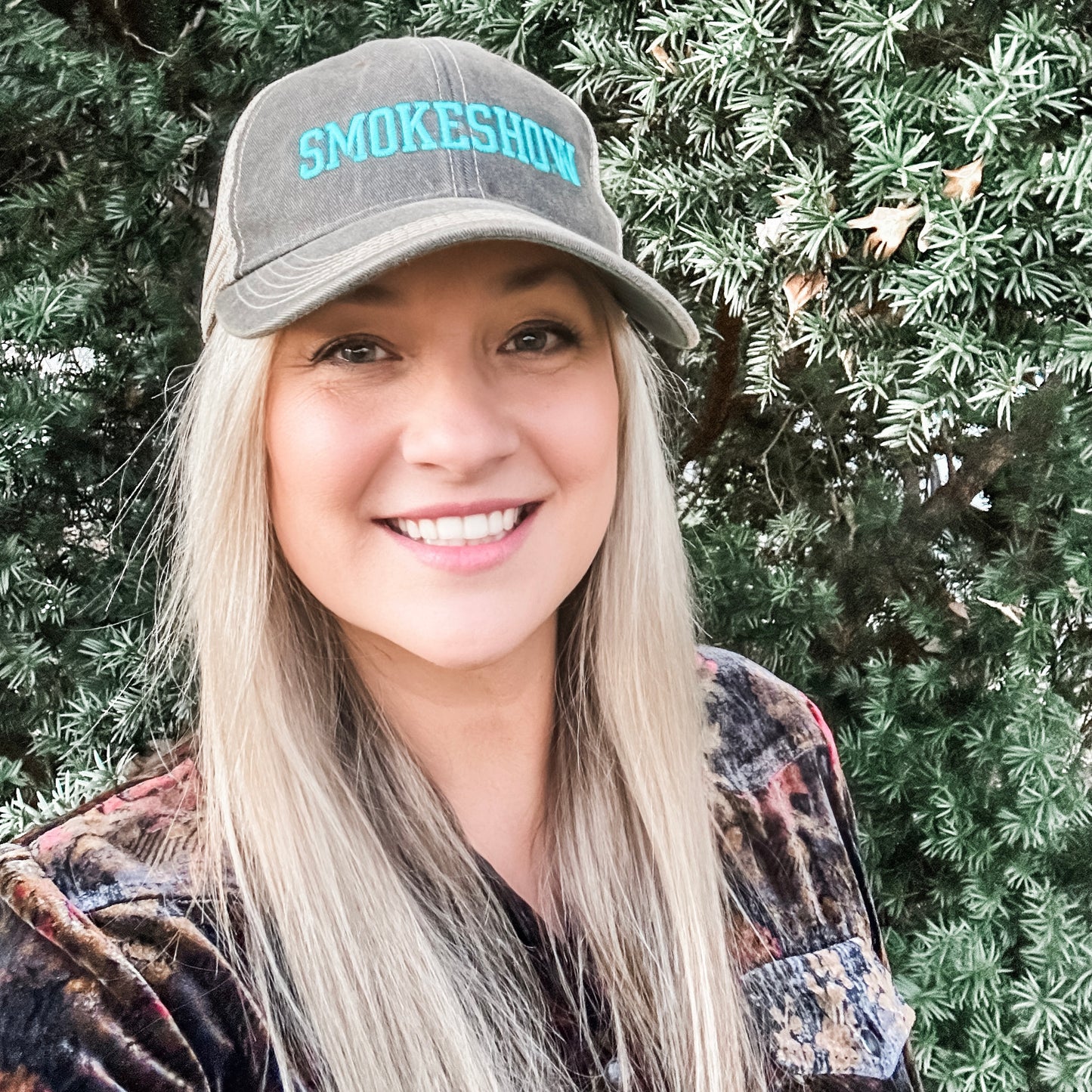 Woman smiling in Smokeshow hat, Facetune image