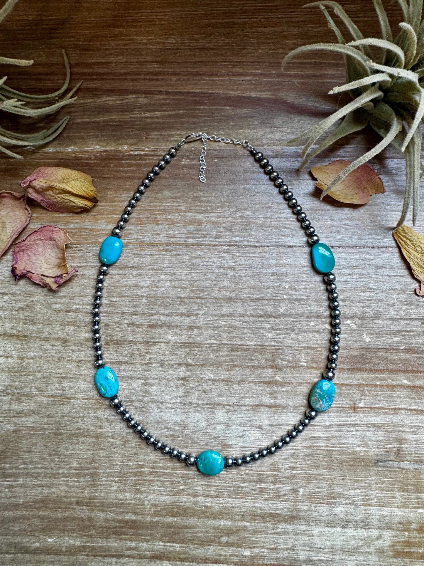 Turquoise beaded necklace on wood surface